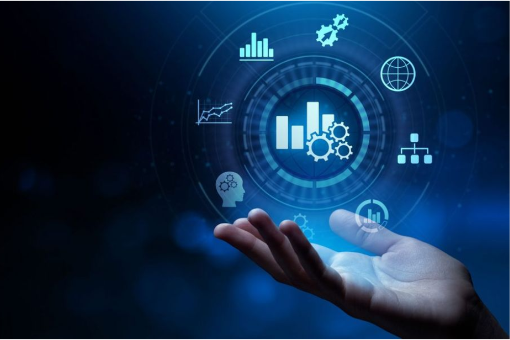 Mão segurando holograma digital com gráficos e ícones de análise de dados representando Business Intelligence e tomada de decisão baseada em dados.